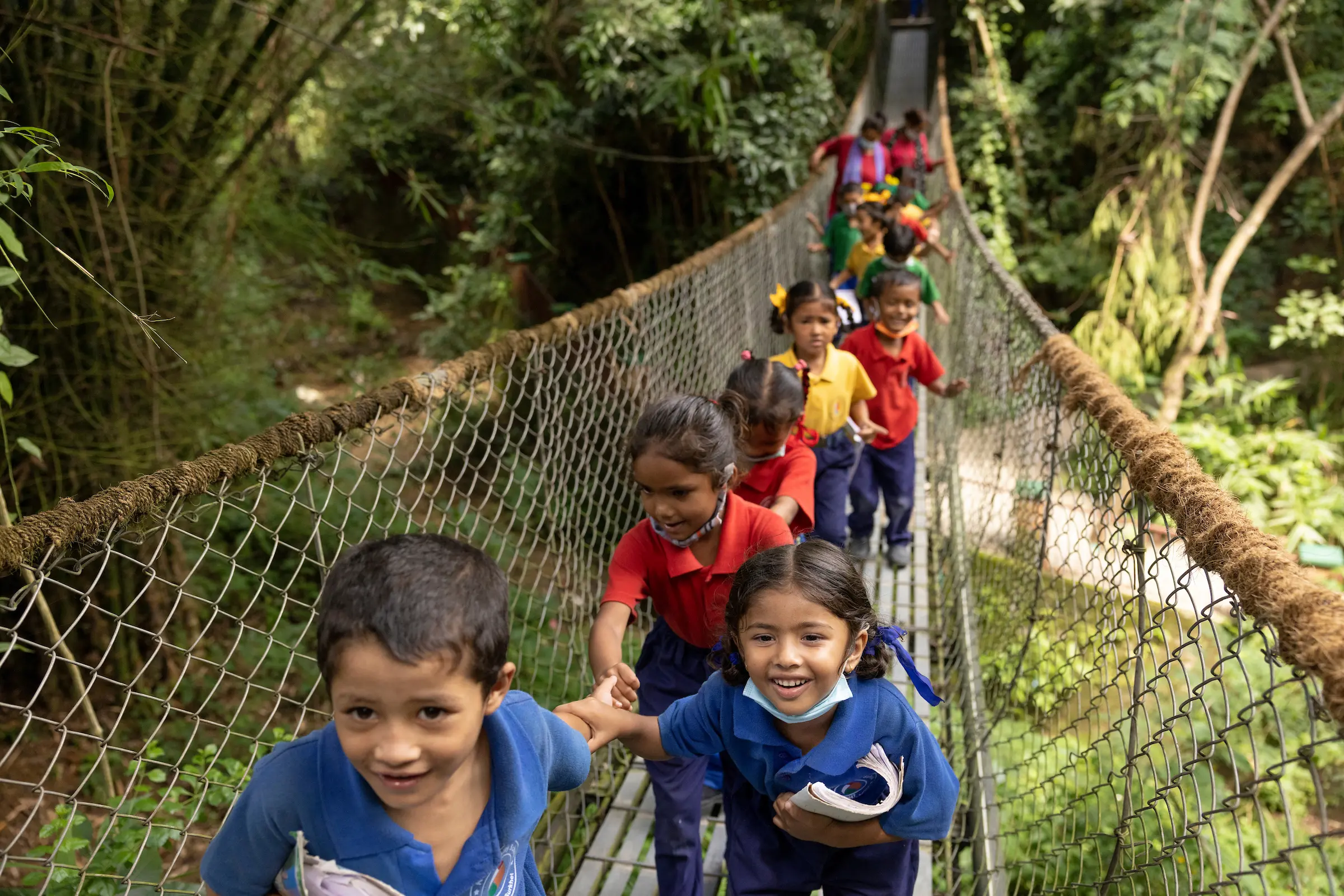 Children from the BlinkNow community crossing a suspension bridge in Nepal.
